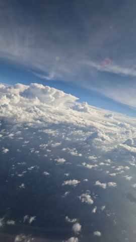 Heavy clouds covering the French Alps, filmed from an airplane clear window, showing dramatic aerial scenery above the mountains.