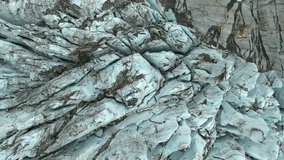 A top-down drone footage of the Argentiere Glacier revealing deep crevasses and blue ice layers mixed with rock debris in the French Alps - Powered by Shutterstock - Get 15% off with code: PIKWIZARD15