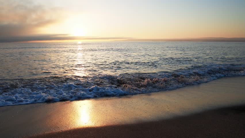 Black Sea and beach nearby against a sky with clouds and a dawn sun