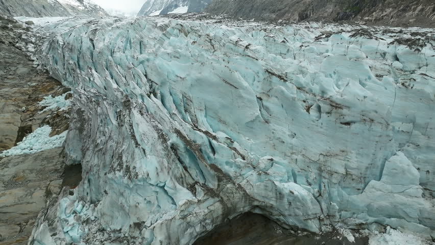 An aerial view of the Argentiere Glacier revealing massive blue ice flow cascading across the Mont Blanc massif, France