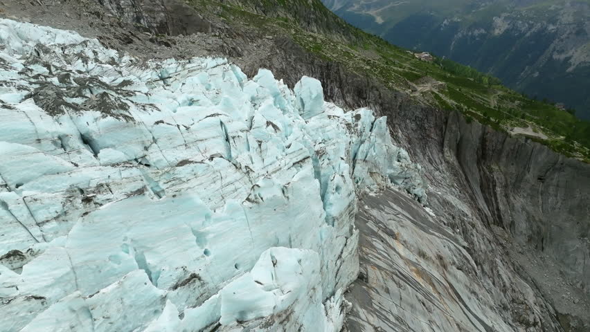 An aerial view of the Argentiere Glacier showing sharp blue ice ridges and rock walls in the Mont Blanc massif, France