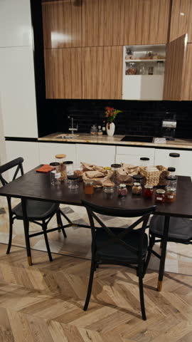 Vertical shot of plastic containers prepared for restock placed on dark wooden table located in center of modern kitchen
