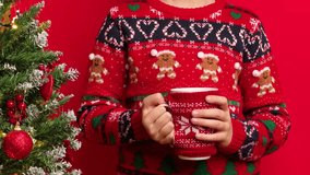 A child holds a warm Christmas drink while wearing a festive sweater, captured in natural real-time motion - Powered by Shutterstock - Get 15% off with code: PIKWIZARD15