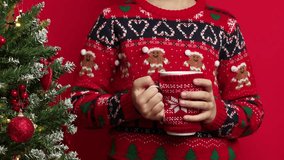 Slow motion shot of a child holding a warm holiday drink in festive sweater, creating a cozy Christmas atmosphere - Powered by Shutterstock - Get 15% off with code: PIKWIZARD15