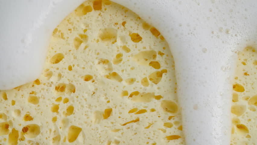 Bubbles of white soap foam. Moving Soap foam popping bubble on backdrop. Soap sud macro structure. Clean, cleaning concept, laundry, shower. 