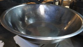 A professional chef wearing black gloves carefully cracks a large number of eggs into a stainless steel bowl, then uses a wire whisk to beat the eggs until they are combined into a smooth - Powered by Shutterstock - Get 15% off with code: PIKWIZARD15