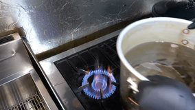 A professional chef prepares spaghetti pasta, dropping the dry noodles into a large pot of boiling water and stirring them with a wooden spoon before draining and tossing the cooked pasta. - Powered by Shutterstock - Get 15% off with code: PIKWIZARD15