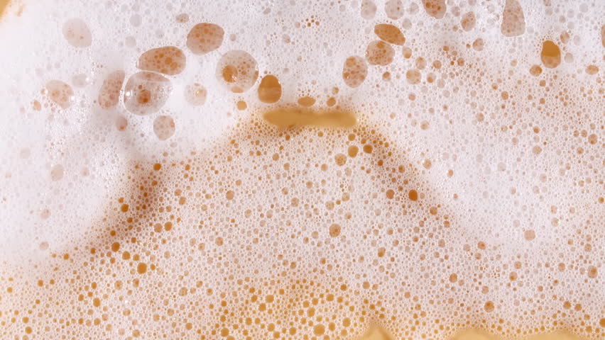 Bubbles of white soap foam. Moving Soap foam popping bubble on a orange backdrop. Soap sud macro structure. Clean, cleaning concept, laundry, shower. 