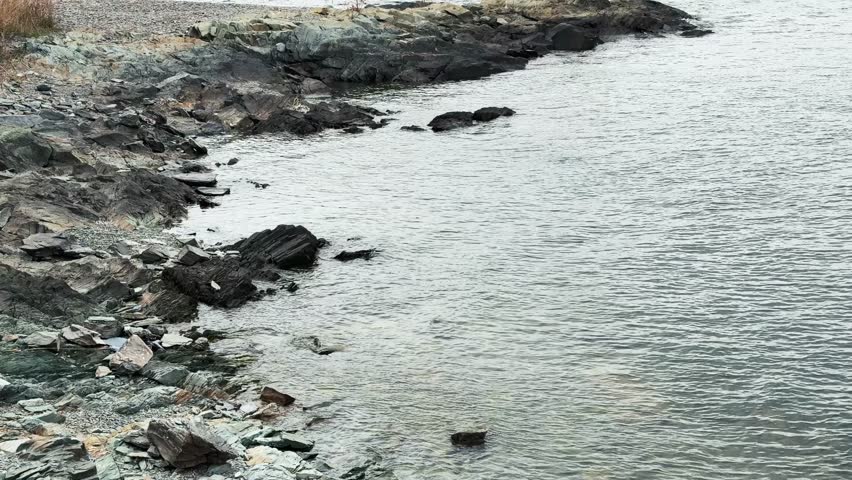 High angle rocky shoreline with rippling sea water