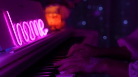 Female hands playing piano under pink neon light with soft bokeh in the background. Cozy home atmosphere, gentle motion and artistic mood - Powered by Shutterstock - Get 15% off with code: PIKWIZARD15
