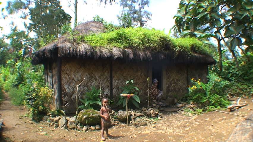 PAPUA NEW GUINEA - NOV.5: Native young boy standing in front of a traditional hut made with woven bamboo, in the Mt. Hagen Highland area in Papua New Guinea, November 5, 2008.