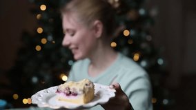 woman try Christmas cake slice and festive blue mug on table, warm bokeh lights in background - Powered by Shutterstock - Get 15% off with code: PIKWIZARD15