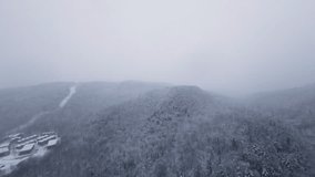 FPV footage diving gently toward a fog-filled alpine valley as thick snow obscures distant mountains, creating a dramatic premium winter mood. - Powered by Shutterstock - Get 15% off with code: PIKWIZARD15