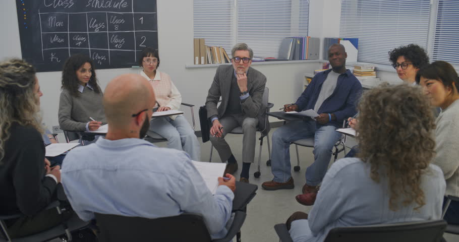 Circle of Adult Learners Participates in Classroom Workshop, With Mature Teacher Leads Speaking Group. Concept of Attentiveness and Involvement, Professional Yet Relaxed Educational Environment.