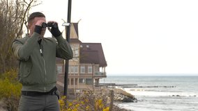 A man observes the situation on the beach through binoculars. A man observes the situation on the seashore through binoculars. - Powered by Shutterstock - Get 15% off with code: PIKWIZARD15