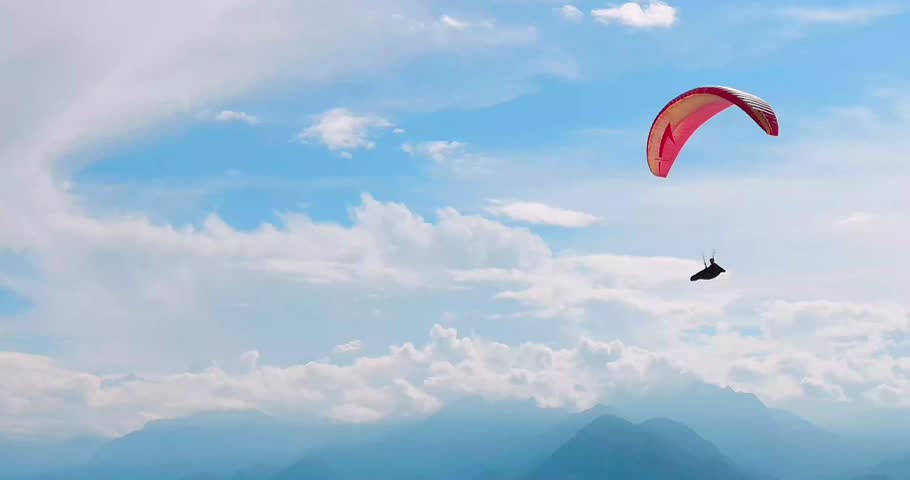 4K footage of a paraglider soaring under a clear blue sky. Perfect for adventure videos, travel content, extreme sports footage, tourism promos, cinematic sequences, and inspirational outdoor visuals.