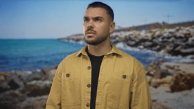 Man frowns with knit eyebrows in studio near sunlit rocky shore for a coastal portrait; seriousness. - Powered by Shutterstock - Get 15% off with code: PIKWIZARD15