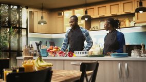 African american couple following online recipe for a fresh salad, looking at the steps and ensuring easy vegetables mix. Cute boyfriend and girlfriend cooking together for a vegan meal. Camera A. - Powered by Shutterstock - Get 15% off with code: PIKWIZARD15