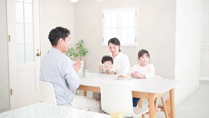 Video of a baby enjoying a snack in a beautiful dining room with a family of four　	