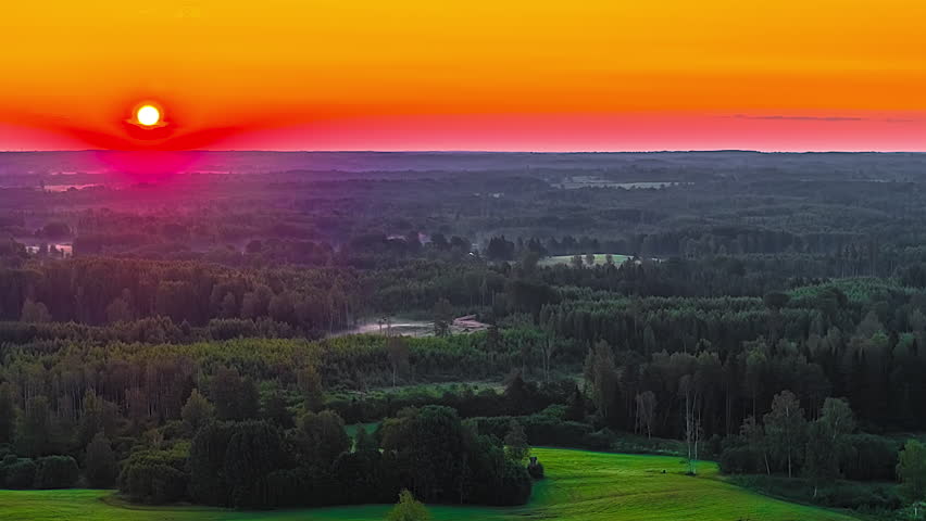 Moon Rising Against Red Fiery Dusk Sky Over Dense Forested Plains. Timelapse