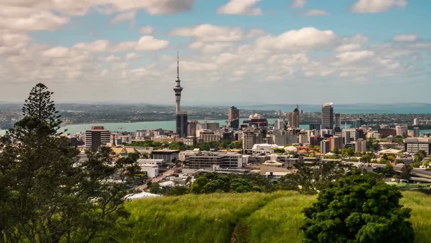 A dynamic time-lapse of Auckland, New Zealand, showcasing the city skyline, moving clouds, and vibrant urban atmosphere as day transitions into evening.