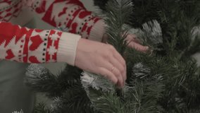 Close up of hands adjusting artificial Christmas tree branches before holiday decoration at home. Concept of Christmas preparation and winter celebration - Powered by Shutterstock - Get 15% off with code: PIKWIZARD15