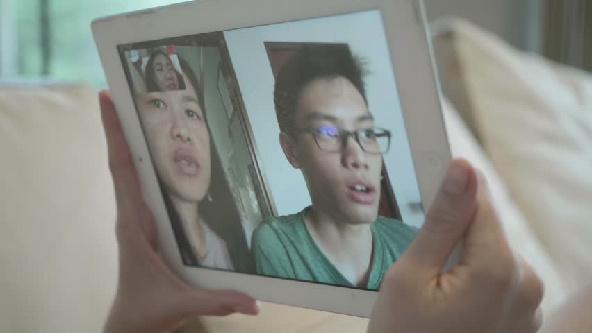 This image depicts two individuals engaged in a video chat on a tablet, showcasing the modern way of communication. The scene highlights the importance of technology in connecting people from differen - Powered by Shutterstock - Get 15% off with code: PIKWIZARD15