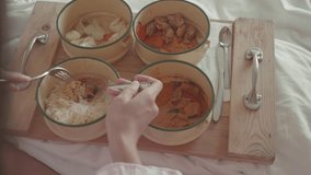 A relaxing breakfast scene featuring bowls of comforting food on a wooden tray. Soft bed linens set a cozy atmosphere, perfect for enjoying a leisurely morning. - Powered by Shutterstock - Get 15% off with code: PIKWIZARD15