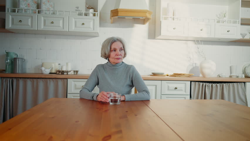 Happy senior lady smiling to camera, portrait in home interior, pretty housewife . Positive emotions and good mood, good feelings and healthcare in old age, better aging, grey-haired caucasian woman