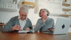Internet addicted senior woman and husband reading book communicating at home. Pastime and leisure in weekend, aged people learning new knowledge, portrait of aged spouses sitting in kitchen together - Powered by Shutterstock - Get 15% off with code: PIKWIZARD15