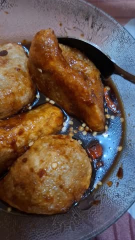 Close-up Video of Palembang Pempek (Indonesian Fish Cake) Doused with Sweet and Sour Cuko Sauce, Delicious Popular Sumatran Food