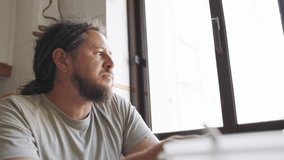 Thoughtful man with dreadlocks eating meal by the window - Powered by Shutterstock - Get 15% off with code: PIKWIZARD15