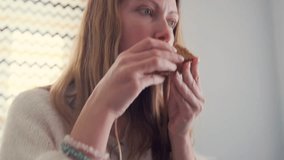 closeup of woman savoring sandwich, woman with focused expression eating delicious sandwich comfortably at home, closeup image of woman joyfully enjoying tasty sandwich in cozy kitchen environment - Powered by Shutterstock - Get 15% off with code: PIKWIZARD15