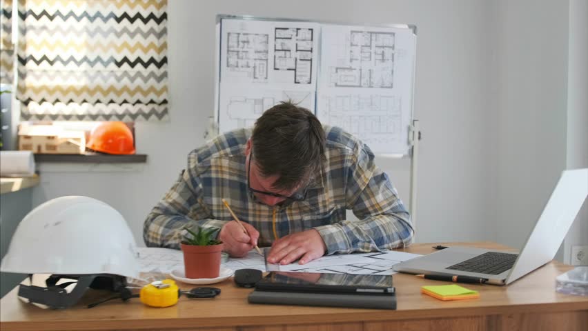 professional architect creates detailed plans using multiple tools and technology, an architect at work actively sketches detailed building plans utilizing both traditional and digital drafting tools