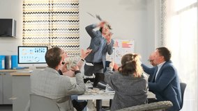 white presenter waving money during pitch to animated audience around conference table; charismatic speaker, engaged colleagues, visible charts and lively gesturing create persuasive demonstration - Powered by Shutterstock - Get 15% off with code: PIKWIZARD15