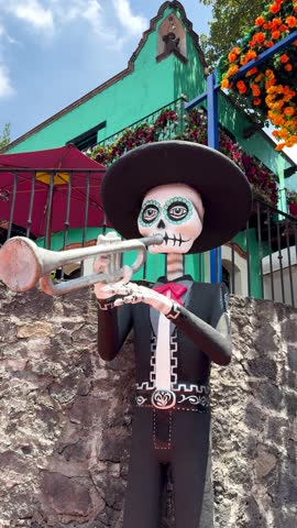 Giant mariachi skull figure outdoors, festive and colorful setting