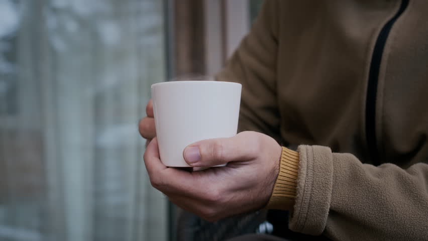 Closeup of unrecognizable hands holding warm cup in cold winter weather creating cozy outdoor atmosphere