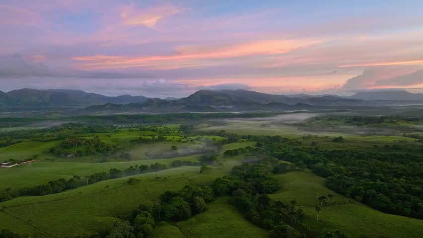 Drone aerial flights at sunset. Beautiful Dominican Republic scenery. A mountain peak rises among the clouds. Large clouds and morning fog hover over the mountain peaks. Beautiful mountain landscape.