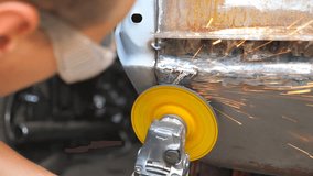 Male repairman or mechanic worker grinding old car body using grinder machine and protective eyewear in workshop. Welder polishing auto with electric professional equipment in garage. Dolly shot - Powered by Shutterstock - Get 15% off with code: PIKWIZARD15