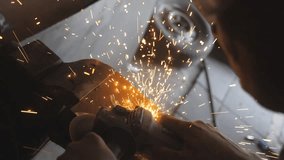 Professional repairman or mechanic worker sawing metal with a circular saw in workshop. Male welder cutting steel using electric grinding wheel and protective eyewear in garage. Crane shot Slow motion - Powered by Shutterstock - Get 15% off with code: PIKWIZARD15