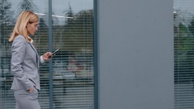 Gadget addict Caucasian adult business woman walking in city with phone mobile smartphone job chat businesswoman 40s female executive walk going near office building in downtown reading social media - Powered by Shutterstock - Get 15% off with code: PIKWIZARD15