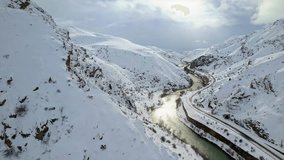 A shimmering river winds through a snowy canyon beside a railway line entering a tunnel, forming a dramatic and atmospheric winter landscape. - Powered by Shutterstock - Get 15% off with code: PIKWIZARD15