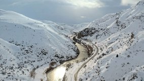 A shimmering river winds through a snowy canyon beside a railway line entering a tunnel, forming a dramatic and atmospheric winter landscape. - Powered by Shutterstock - Get 15% off with code: PIKWIZARD15
