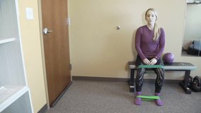 A Caucasian female trainer explaining a Workout exercise using Elastic Bands and resist-A-ball - Powered by Shutterstock - Get 15% off with code: PIKWIZARD15