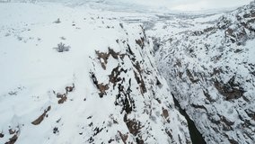 Aerial drone view of a narrow canyon with a river running between steep snowy cliffs. A dramatic and cinematic winter landscape. - Powered by Shutterstock - Get 15% off with code: PIKWIZARD15