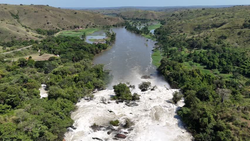 Drone footage showing the Kwanza River flowing toward the Binga Falls in Angola, where the calm surface turns into a powerful cascade through tropical forest