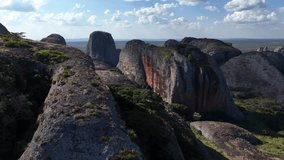Aerial drone footage of Pedras Negras in Angola, showing dramatic black rock formations, deep cliffs, and vast savanna landscape under blue tropical sky - Powered by Shutterstock - Get 15% off with code: PIKWIZARD15