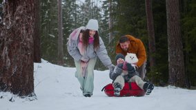 Smiling parents helping excited child on red sled holding small dog while enjoying fun winter playtime in snowy forest - Powered by Shutterstock - Get 15% off with code: PIKWIZARD15
