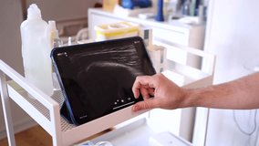 Medical professional analyzing an ultrasound image on a tablet screen while using a portable transducer to perform a thoracic scan on a female patient lying on an examination bed in a clinic - Powered by Shutterstock - Get 15% off with code: PIKWIZARD15