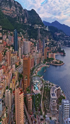 Aerial view of the city center of Monaco. Establishing shot showcases luxury yachts moored in Monaco Bay, the Palais Princier de Monaco, and luxury apartment buildings of Monte Carlo